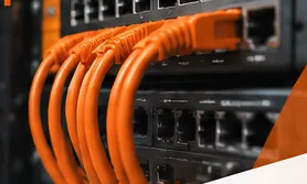 Patch panel δικτύου με πορτοκαλί καλώδια σε rack